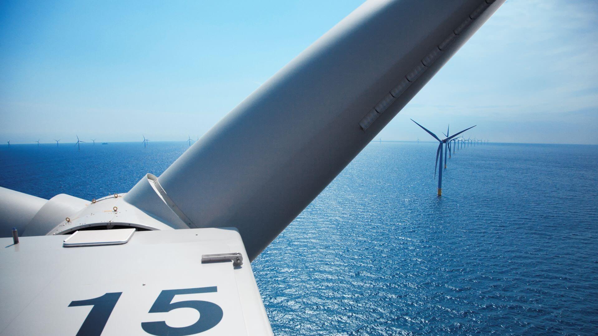 Close up of offshore wind turbine blade with sea behind