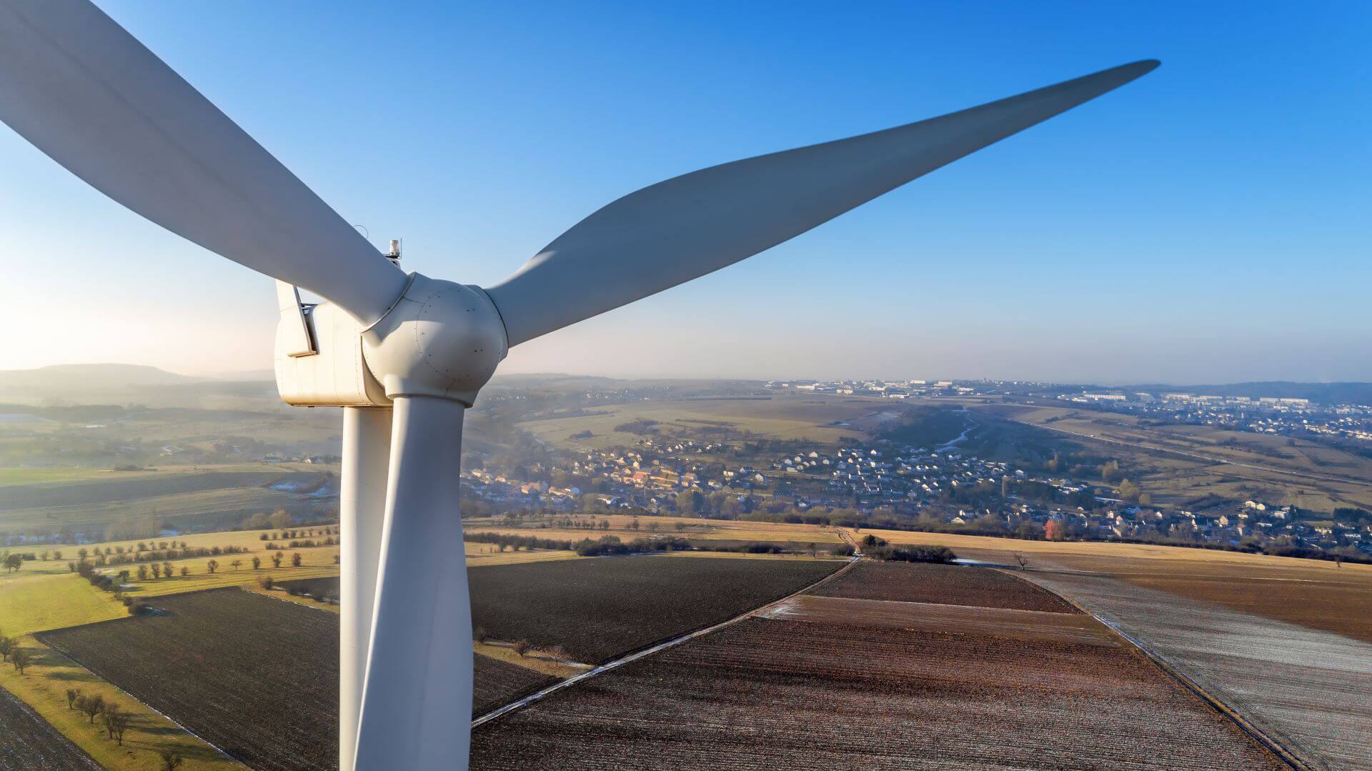 Close up of onshore wind turbine against blue sky background