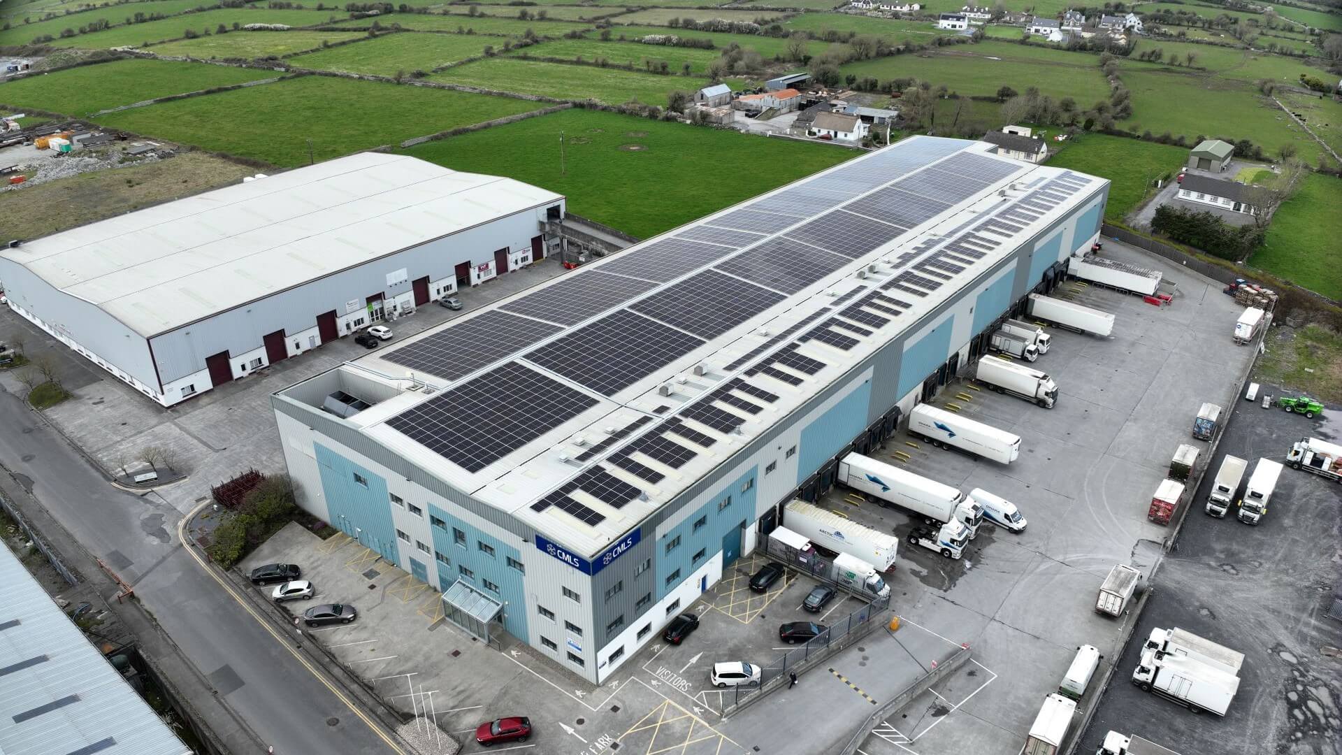 Aerial view of warehouse with solar panels on roof