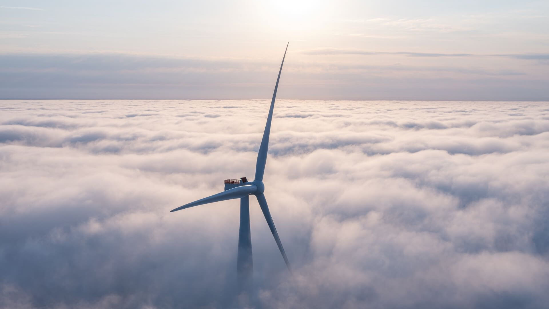 Aerial view of wind turbine above the clouds