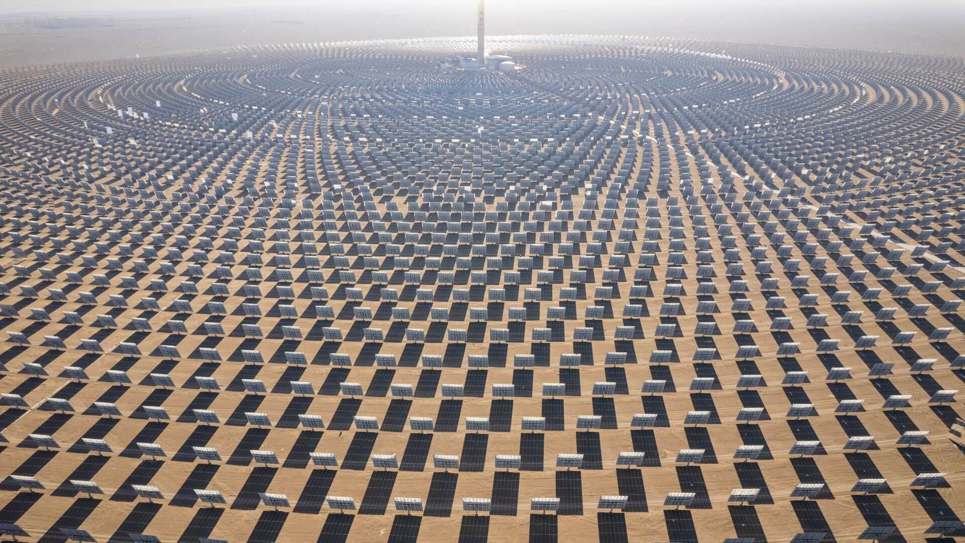 Rows of solar panels fanning our from central point in desert