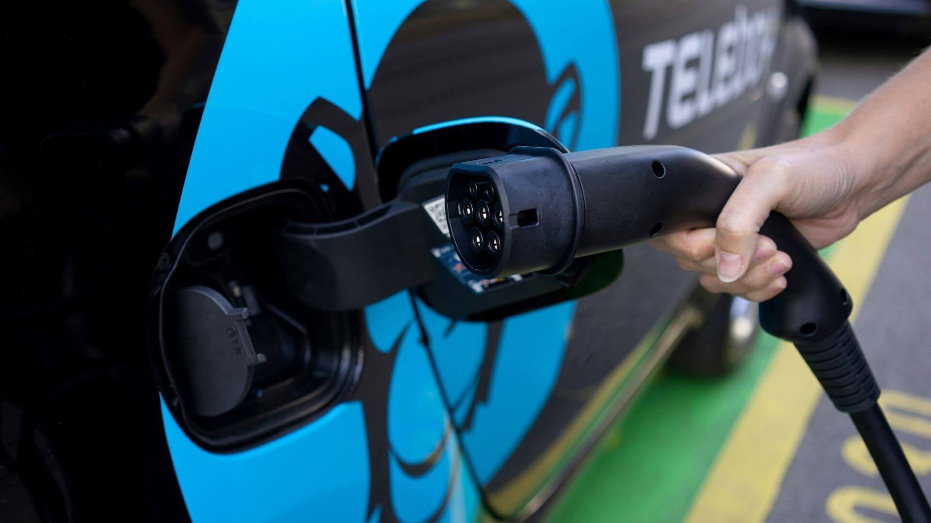 Electric car being plugged in to charge