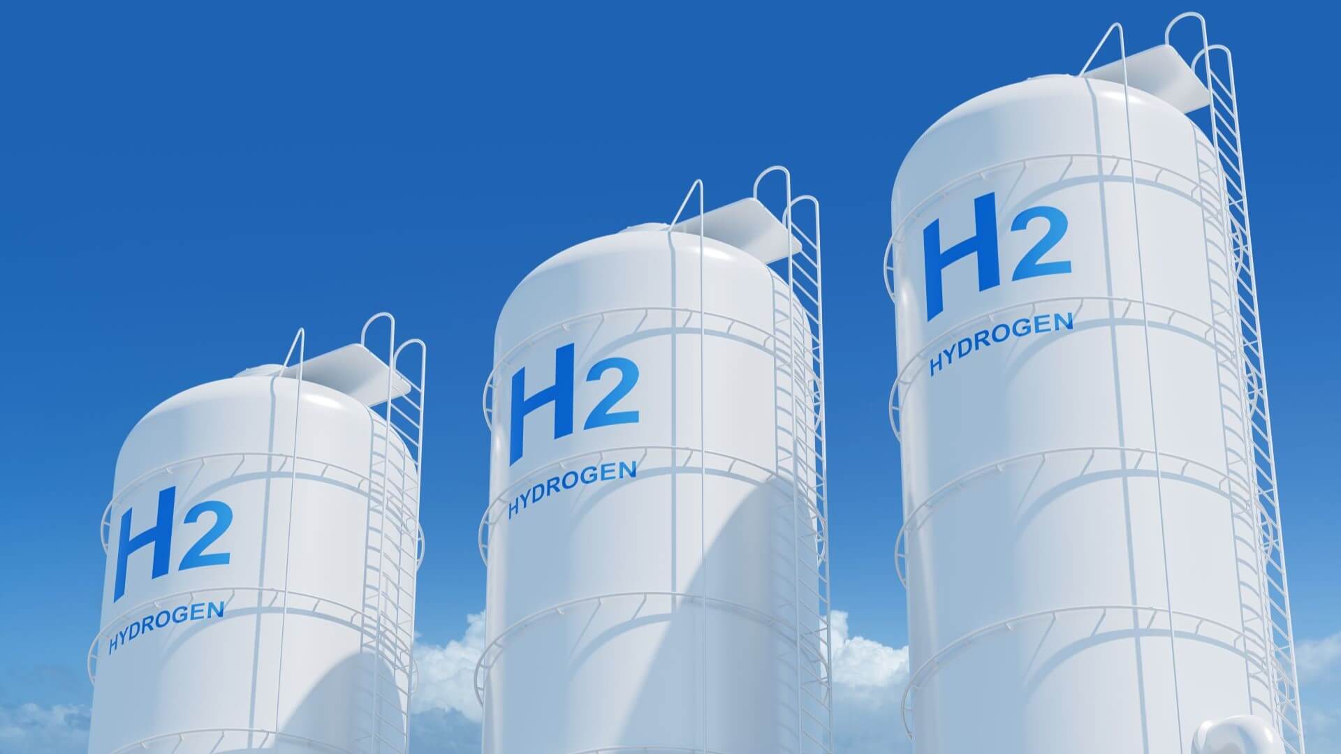 Row of three hydrogen tanks with blue sky behind