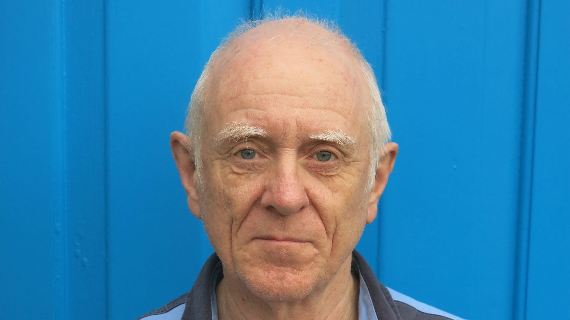 Head and shoulders photo of Steve Hodgson standing in front of bright blue background