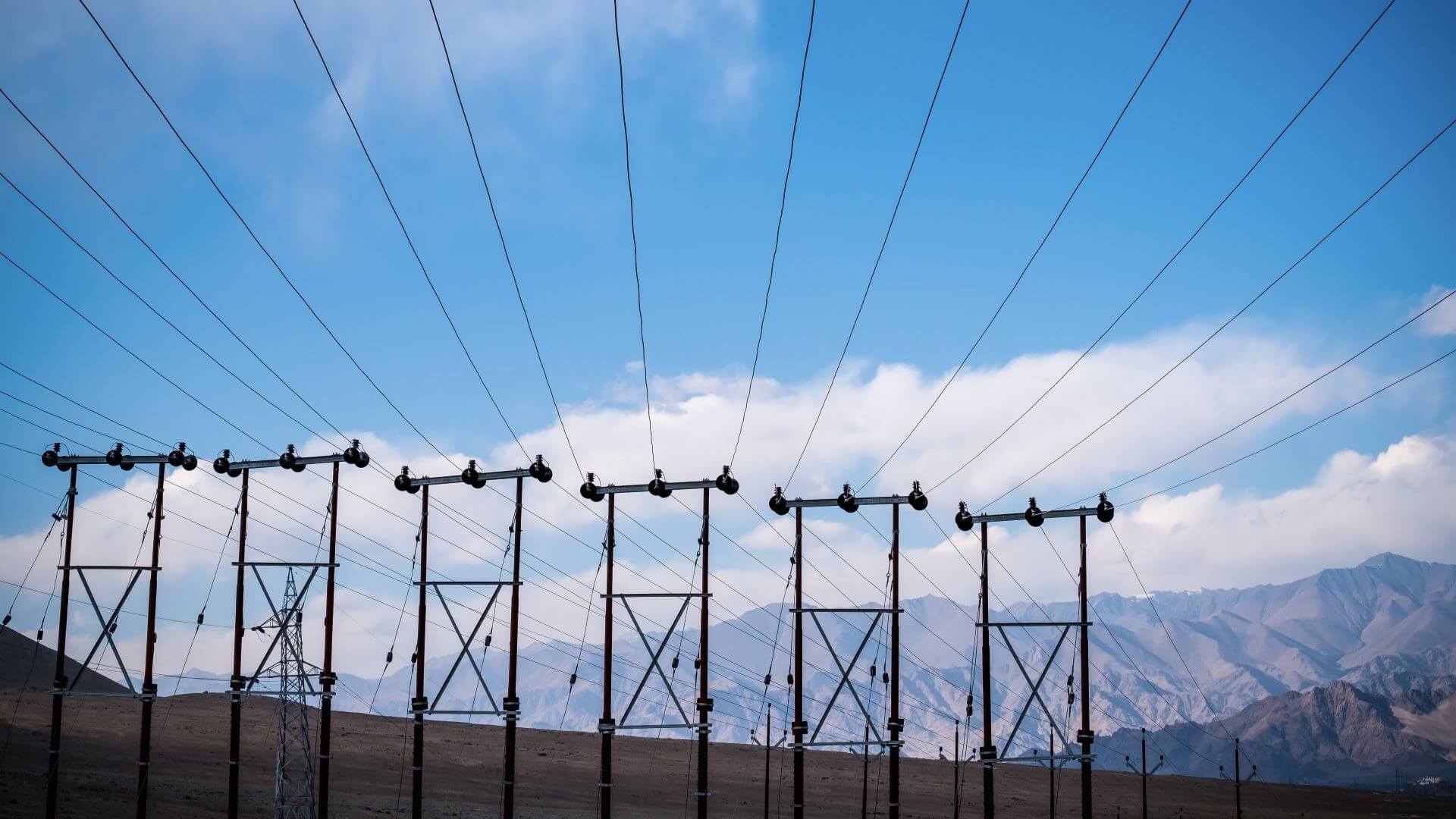 Row of power lines with mountains in background