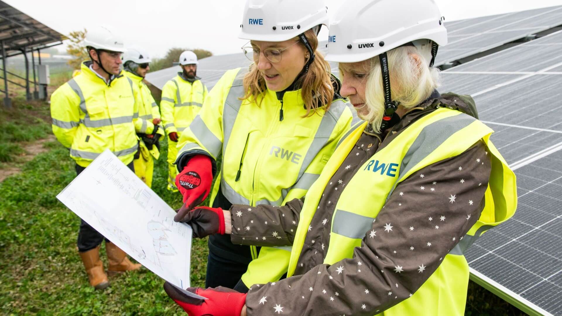 Officials looking at plans in between solar panel rows