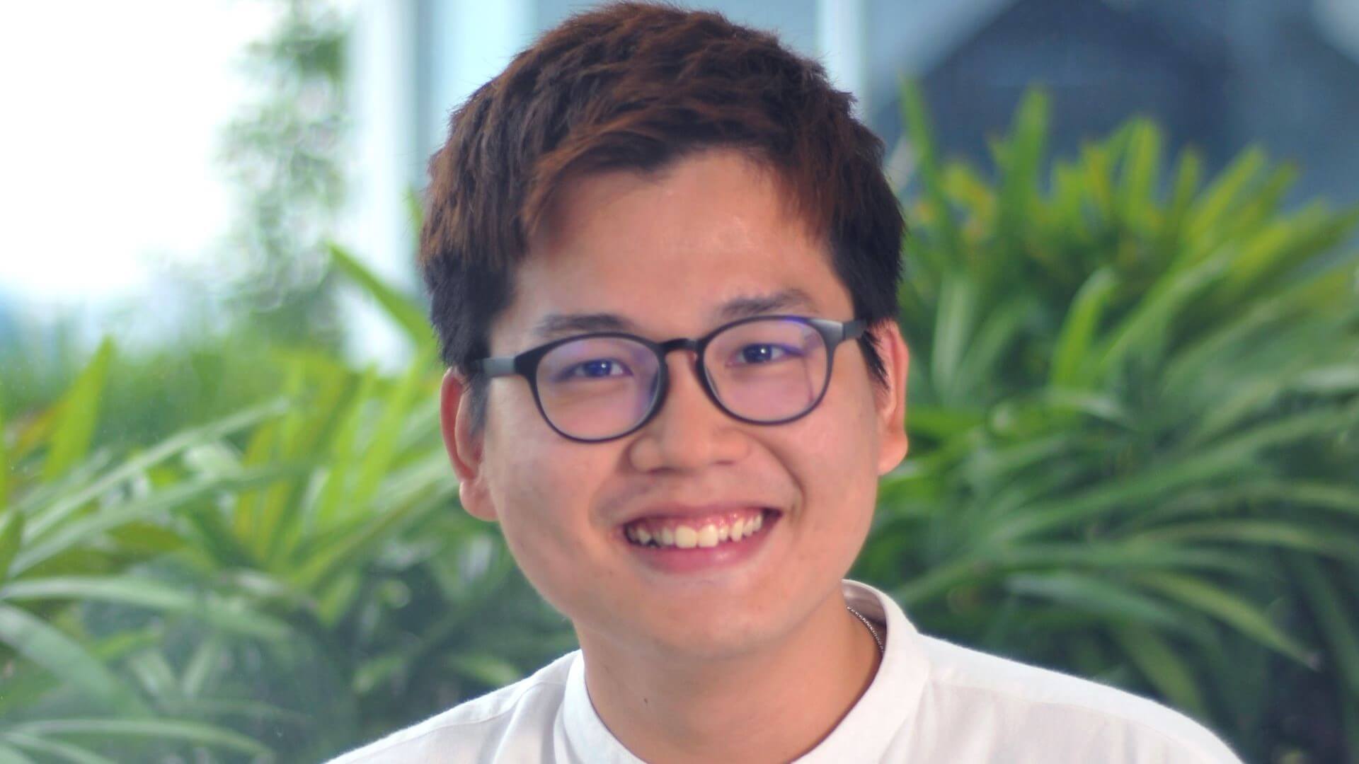 Head and shoulders photo of Austin Lim, with green foliage behind