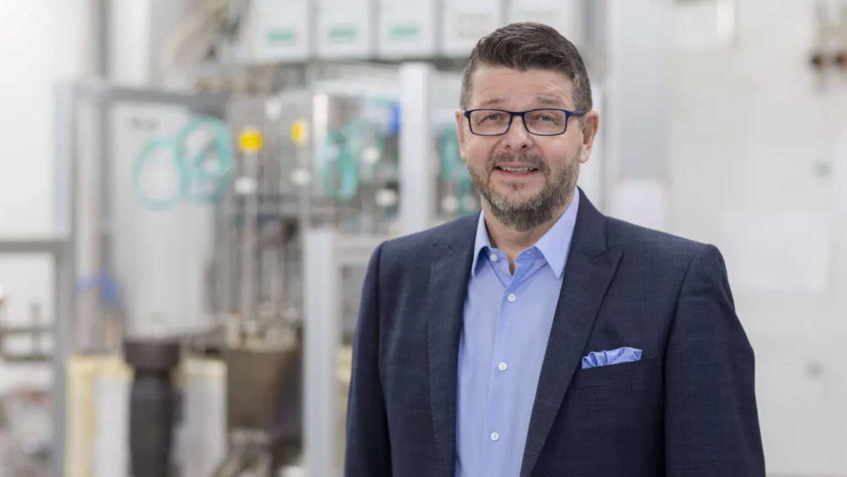 Head and shoulders photo of Research Professor Jari Kiviaho with lab equipment in background