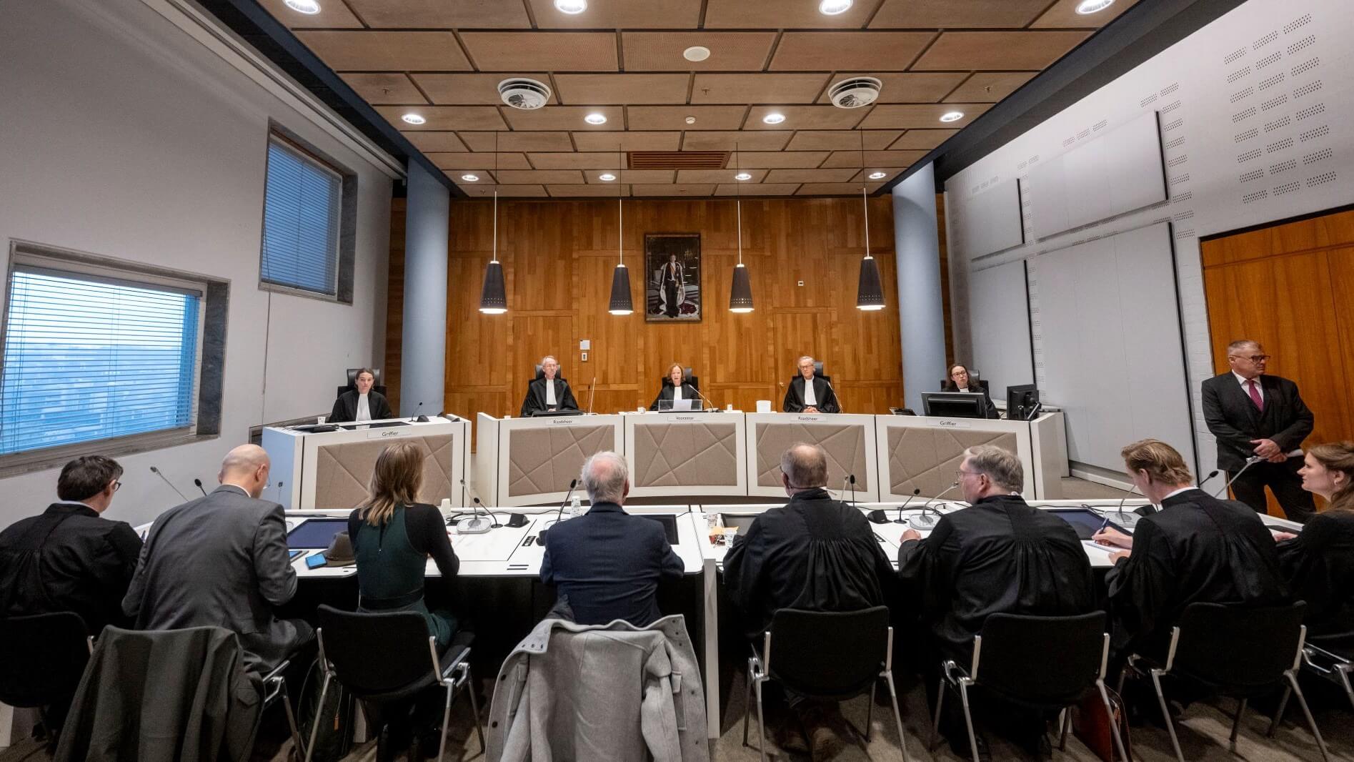 A group of people sitting at a table in a courtroom