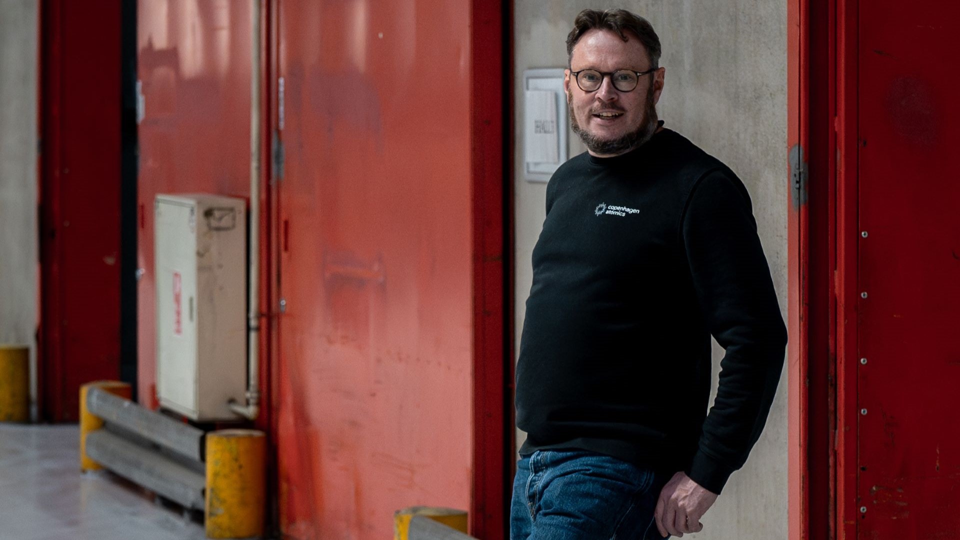 Thomas Jam Pedersen, Founder and CEO, Copenhagen Atomics, leaning against wall of metal industrial building