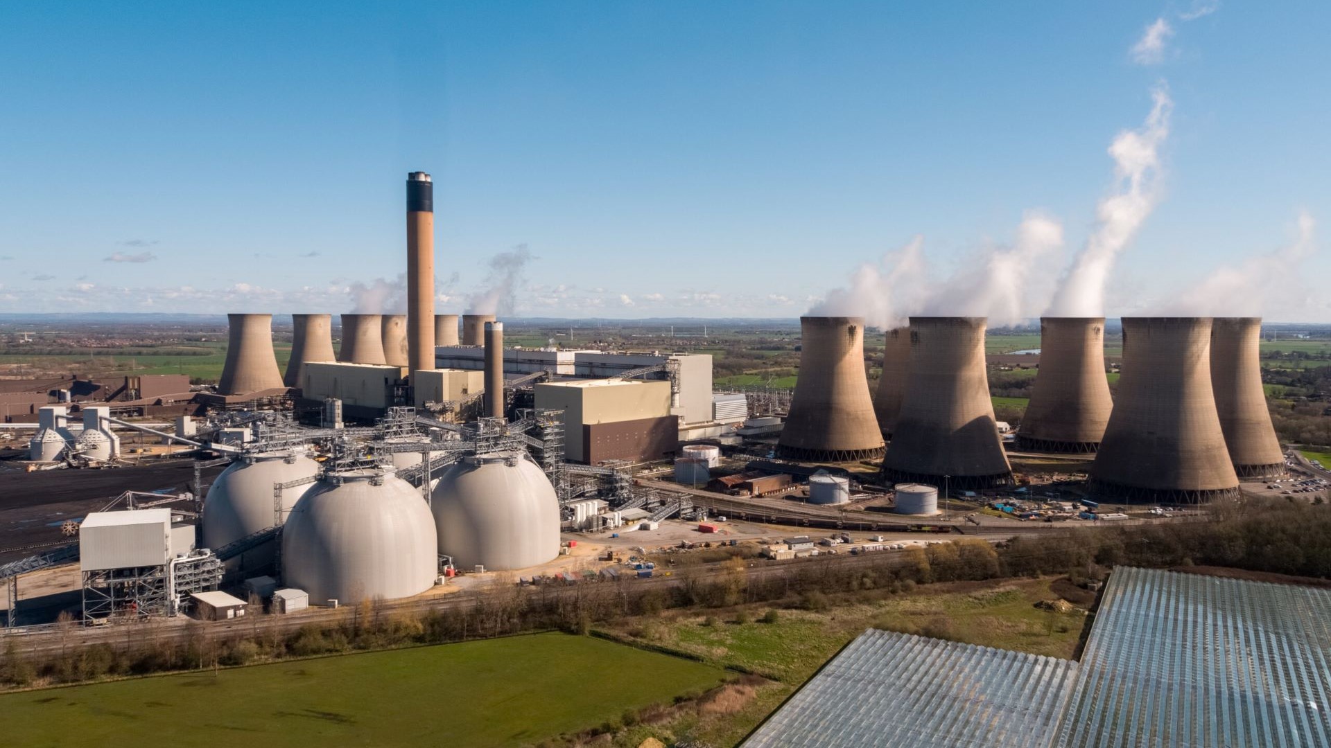 Distant view of power station cooling towers and biomass domes